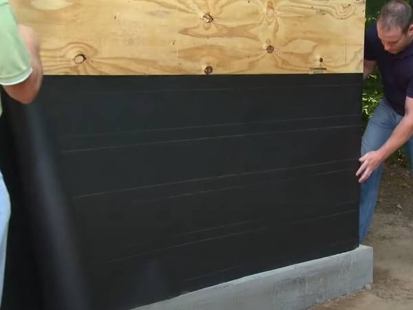 Two workers are placing the sheathing.