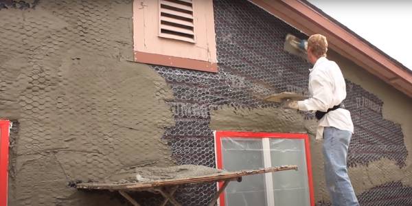 Apply the first layer of mortar onto the metal lath fastened onto the wood wall.